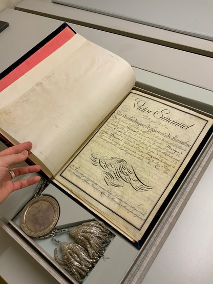 The original Treaty of Turin, bound in parchment paper with a special seal dangling from it in a silver box and tassels. The author’s hand is visible.