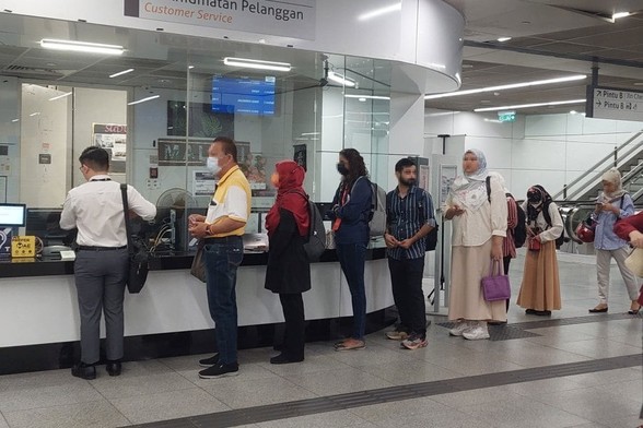 Train commuters lining up at a station's counter. / Photo from linked article.