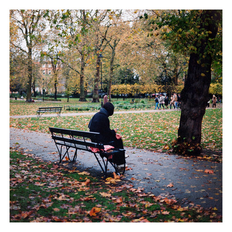 Phot of a woman sitting on a park bench.