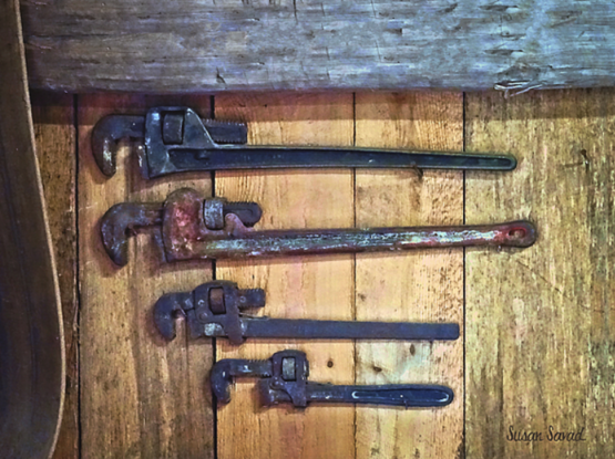 A monkey wrench, also called an adjustable spanner, especially in Britain,  is a wrench with one fixed and one adjustable jaw which permits it to grasp nuts of different sizes.