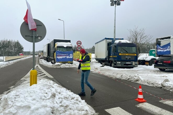 Kamil Gorzkowski remet en place le cordon bloquant la circulation des camions. © Photo Helene Bienvenu pour Mediapart