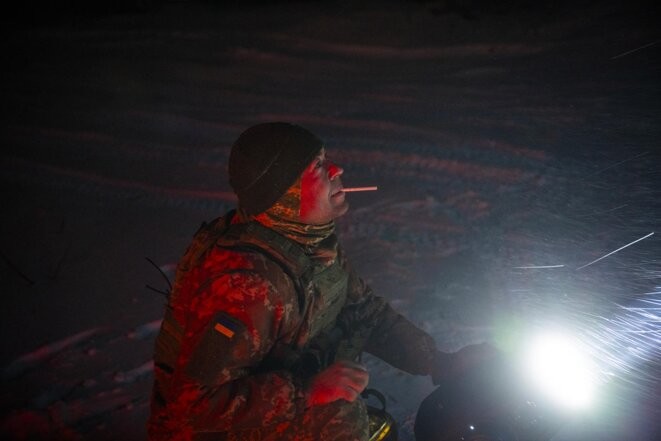 Sidar, un soldat de la brigade de la défense territoriale basée à l’est de Kyiv et chargée de la défense anti-aérienne, utilise un projecteur au cours de son travail pendant la nuit du 7 décembre 2023 en Ukraine. © Photo Pete Kiehart pour Mediapart