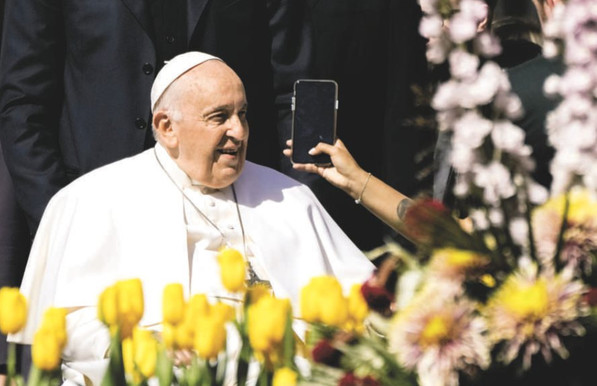 Pope Francis at the Vatican being shown the screen of a smartphone.