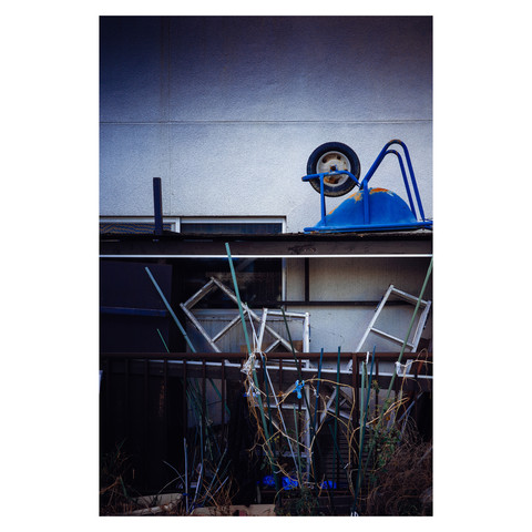 Amidst the orderly disarray, a cluster of ladders, an upturned wheelbarrow, and bamboo poles strike a composition that rivals the intentionality of graphic design. This accidental arrangement on a Nagoya backlot stages an unspoken challenge to the passerby—find beauty in the everyday, the overlooked, the seemingly mundane that, upon a closer look, reveals a narrative of life's unplanned artistry.