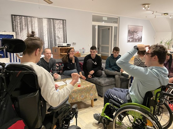 Sieben Leute sitzen am Tisch und besprechen den Workshop.