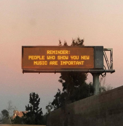 A highway sign that reads:

REMINDER:
PEOPLE WHO SHOW YOU NEW MUSIC ARE IMPORTANT

Sorry, didn’t mean to yell, but that’s how the words were copied out of the image.