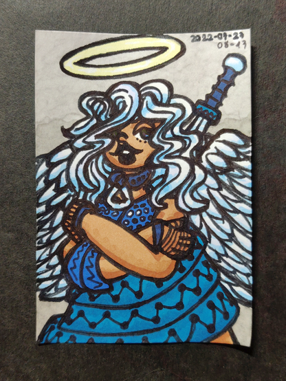 Un dessin représentant un personnage au genre ambigu avec des ailes et des cheveux blancs, une auréole jaune, une épée rangée sur le dos, les bras croisés et une tenue bleue ; elle porte un collier bleu avec une boucle argentée et sourit à la caméra ; sur fond gris évoquant des nuages.