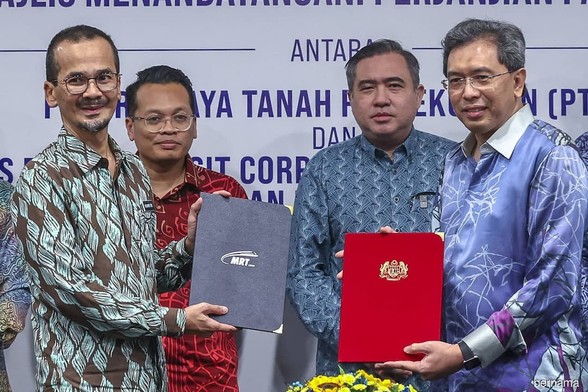 Two people exchanging documents with the others witnessing it. / Photo from linked article.