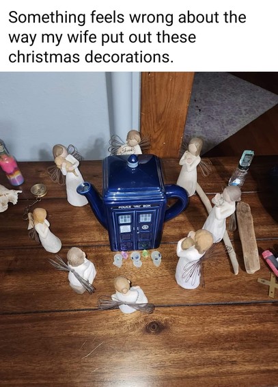picture of a Tardis-shaped teapot with ceramic angels arranged around it
meme-text: „Something feels wrong about the way my wife put out these christmas decorations.“