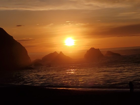Old Sol making a statement: a big orange ball of plasma framed between two of my favourite rocks coming up out of the ocean.  There are a few clouds, but not nearly enough to obscure the orange fireball.