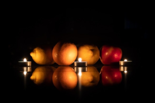 Se puede ver un bodegón con distintas frutas (limón, naranja, manzana) iluminado con velas.

You can see a Still Life with fruits (lemons, orange and apple) iluminated with candle light.