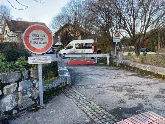 French sign saying “Service Fiscal attention passage interdit” and assorted barriers stopping vehicular passage, but open to pedestrians