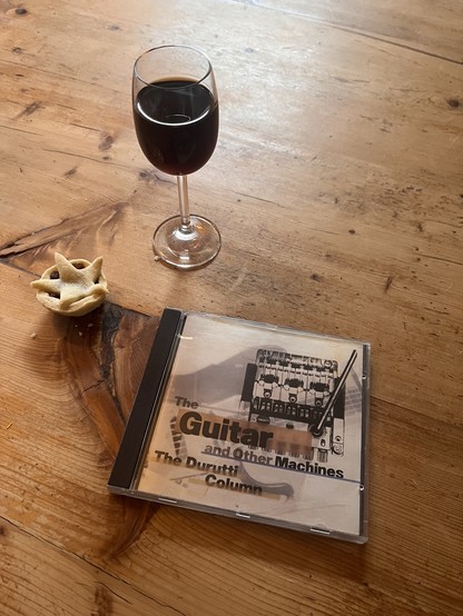A compact disc box for “The Guitar and Other Machines” sits on the old pine table we bought from Vashti Bunyan, next to it a small home-made mince pie with a little pastry star in top and a small glass of ‘sherry’.