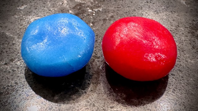 Close-up shot of two small Airhead Bites candies. The left one is blue in color and the right one is red, reminiscent of Flickr’s logo of a blue dot and red/magenta dot.