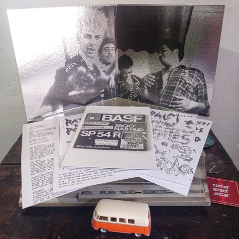 Capa gatefold aberta do disco com encartes da reedição.