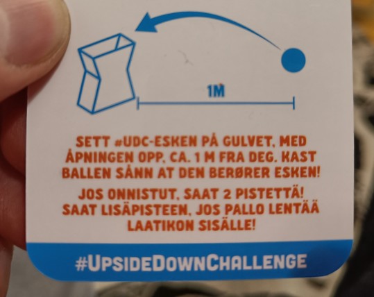 Kortissa teksti:
"Sett «UDC-esken på gulvet, med åpningeb opp. ca. 1 m fra deg. Kast ballen sånn at den berører esken!"