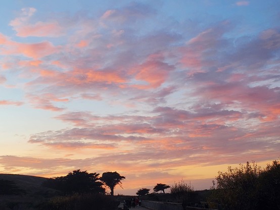 Pink cloud-painting in the afterglow of sunset, with pale blue skies peeking out.