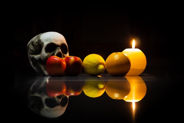 Se puede ver un bodegón de frutas (manzanas, limón y naranja) iluminadas por una vela a la derecha y en la izquierda, por detrás, una figura de una calavera.

You can see a still life of fruits (apples, lemon and orange) lightning with a candle in the right and a skull in the left and back.