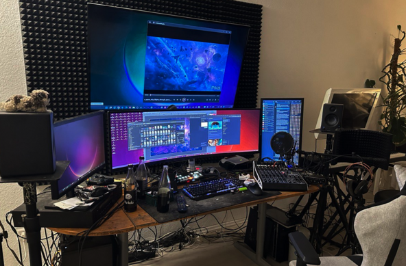 Setup 2023

Beschreibung von Bing:
Das Bild zeigt einen komplexen Arbeitsplatz mit mehreren Monitoren, einer Tastatur, einer Maus und Audioausrüstung auf einem Schreibtisch. Um den Arbeitsplatz herum sind schallabsorbierende Platten angebracht, und es stehen Zimmerpflanzen. Die Beleuchtung im Raum ist gedämpft, und die Monitore sind die Hauptlichtquelle. 
Besonders auffällig ist das Multiscreen-Setup, das aus mehreren Monitoren unterschiedlicher Größen und Ausrichtungen besteht. Einer der Monitore ist an der Wand montiert und zeigt ein buntes abstraktes Bild. Dieser könnte als Gaming-Screen dienen. 