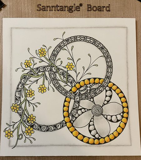 Three interconnected rings with decorations in the rings and flowers drawn wrapping around one and inside another 