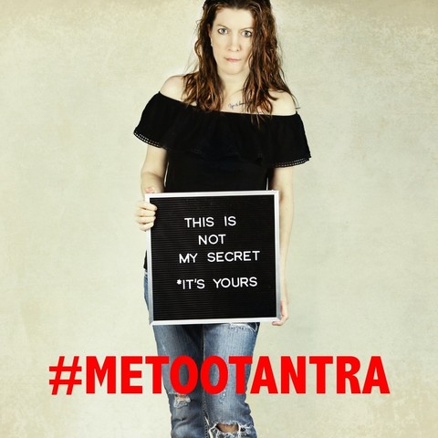 Une femme se tient debout face à nous et porte une pancarte sur laquelle est écrit : "This is not my secret, it's yours". Il est écrit en dessous le hashtag #MeTooTantra.