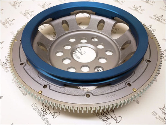 A gear machined out of magnesium, with slightly golden steel teeth and an anodized blue pully attached. 