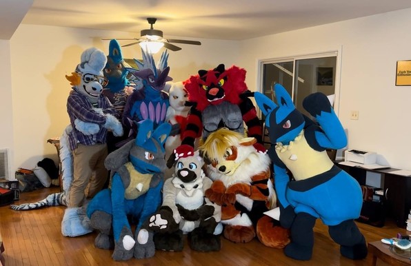 A group photo of Pokemon fursuits, including three Lucarios, an Arcanine, a Toxtricity, a Mudkip, a Zangoose, an Incineroar and a Rockruff.