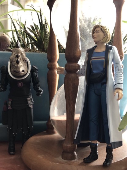 13th Doctor action figure with Judoon action figure amidst the house plants.
