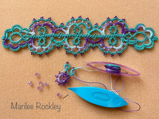 Lace bracelet and pendant in progress in purple and aqua thread with beads.