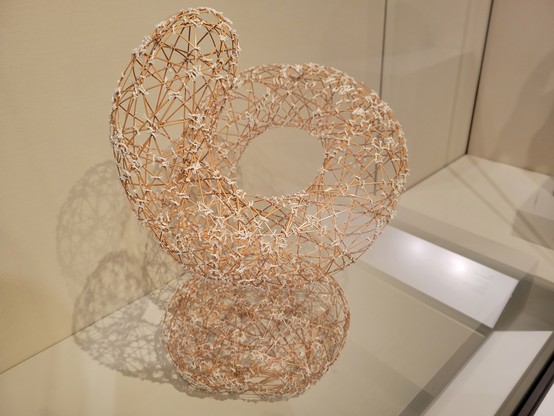 Delicate bamboo sculpture in a spiral shape, about 2 feet tall. The accompanying sign (not shown) reads:

川島茂雄作 「魂の気流」
Stream of Spirit
2006
By Kawashima Shigeo (Japanese, b. 1958)
Heisei period (1989-2019)
Bamboo
Lloyd Cotsen Japanese Bamboo Basket Collection,
2021.165