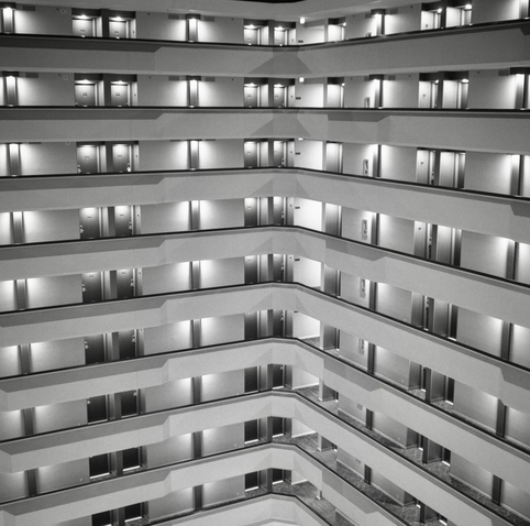 A black and white film photo. An atrium of nine floors inside a Houston hotel which creates an interesting pattern. Thursday, November 23, 2023.
