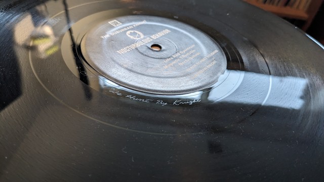 It's a vinyl record from Underground Resistance - UR-11 Nocturbulous Behavior.
The words "We Hunt by Knight" engraved in the runout groove.