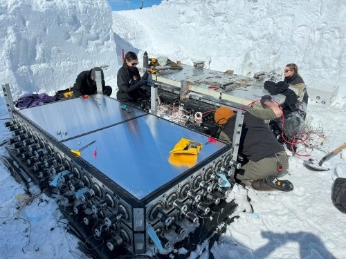 The two detector modules of the Super-Tiger II payload being dismantled. Note the snow walls showing how deep the instrument was buried by three years of snow accumulation. 