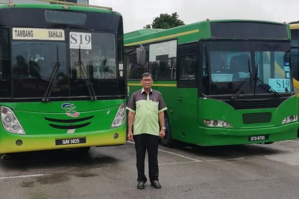 A bus station master standing in front of buses at a station. / Photo from linked article.
