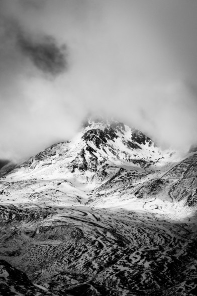 Foto en blanco y negro del pico Peyreget entre nubes y parcialmente nevado.

B&W photography of Peyreget peak between clouds and partially snowy.