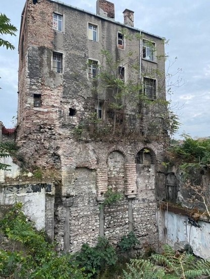 Casa de tres plantas situada sobre unos arcos que a su vez se colocan sobre unas columnas con muros de piedra.