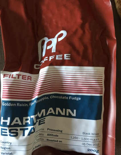 A bag of Papa Palheta coffee for filter from the Hartmann estate. The bag is compressed and looks as if the coffee inside has been vacuum packed.