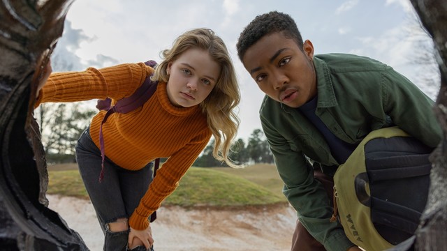 Szene aus dem Film LANDSCAPE WITH INVISIBLE: Kylie Rogers (l.) und Asante Blackk (r.) schauen in eine Art Erdloch