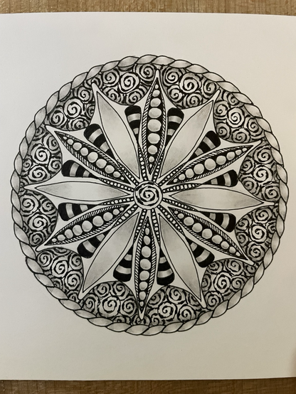 Doodled mandala, spiral in the middle with petals around it (alternating between empty and shaded and filled with orbs), with more spirals outside the petals, surrounded by ribbon effect