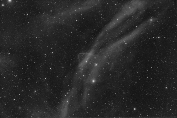 Sh2-126 nebulae:
Image is black and white. Background is black with stars dispersed throughout.

Sprawling from bottom center to upper right of image, in an arc shape, are thick lines of white nebulosity. There is a grouping of particularly bright stars are center of image. There is also some nebulosity at upper edge of image.

At center of image, there is also a notably different "feature" - two thin lines of nebulosity that intersect at a right angle, forming a triangle shape.