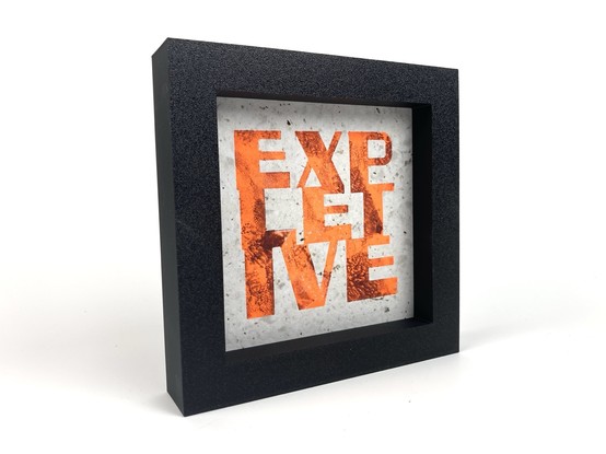 A framed relief print of the word “expletive”.
