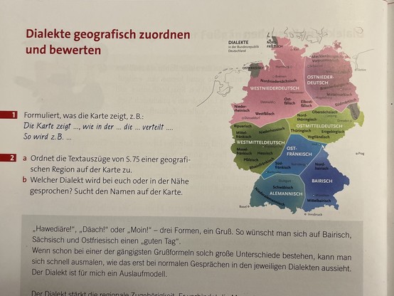 Landkarte mit deutschen Dialekten, keine Legende. Darunter etwa "Ostfränkisch" oder Mitteldeutsch in farbigen Feldern. In grau die beiden friesischen Sprachen sowie Sorbisch. 

Text dazu: 
"Dialekte geografisch zuordnen und bewerten

Formuliert, was die Karte zeigt, z. B.:
Die Karte zeigt ..., wie in der ... die ... verteilt ....
So wird z.B. ...
a Ordnet die Textauszüge von S. 75 einer geografischen Region auf der Karte zu.
b Welcher Dialekt wird bei euch oder in der Nähe
gesprochen? Sucht den Namen auf der Karte.

„Hawediäre!", „Däach!" oder „Moin!" - drei Formen, ein Gruß. So wünscht man sich auf Bairisch, Sächsisch und Ostfriesisch einen „guten Tag" Wenn schon bei einer der gängigsten Grußformeln solch große Unterschiede bestehen, kann man
sich schnell ausmalen, wie das erst bei normalen Gesprächen in den jeweiligen Dialekten aussieht.
Der Dialekt ist für mich ein Auslaufmodell."