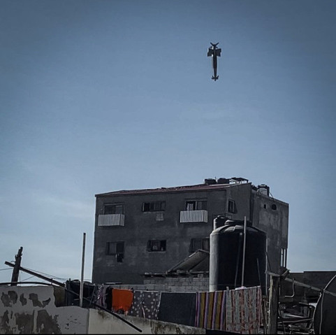 1: A missile falling directly towards the roof of a residential building. In the foreground is another roof with a water tank, satellite receiver, and clothes hanging on a clothesline. 