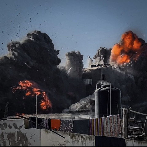 3: The building is barely visible behind large clouds of smoke and fire. 