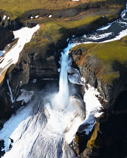 Haifoss Waterfall in Iceland, cascading down a snow-covered mountainside