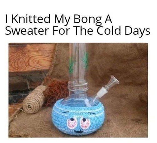 A picture of a simple clear water pipe on a workbench. The waterpipe is wearing a crochet cozy on the bottom bulb that is blue with a cartoon face, including bloodshot eyes.
The caption reads "I Knitted My Bng A Sweater For The Cold Days"