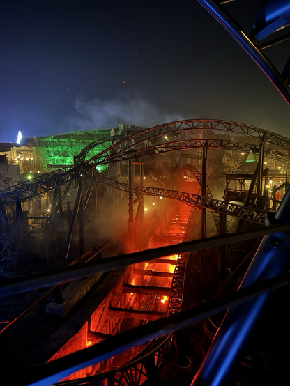 Taron in Klugheim at night. The second launch trench glows red. Elsewhere, yellow and green lights are used. Fog is rising. 
