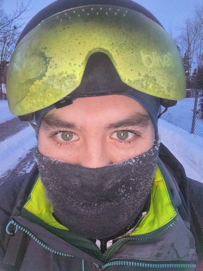 Selfie al amanecer. Voy en mi bicicleta y llevo mi casco con visera y una bufanda que cubre la parte inferior de mi cara. Debajo de la bufanda, una sonrisa.