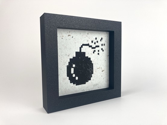 A framed relief print of a bomb from the Apple Macintosh.