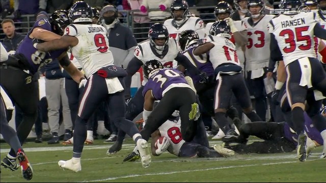 American football game in action with players from two teams, one in dark and the other in white jerseys, involved in a play on the field. Texans player is clearly down before he lost the ball. 